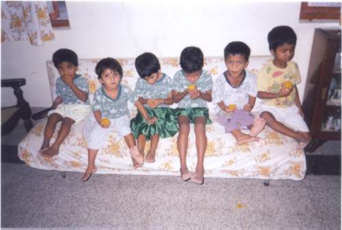 Orphans eating Ladoo